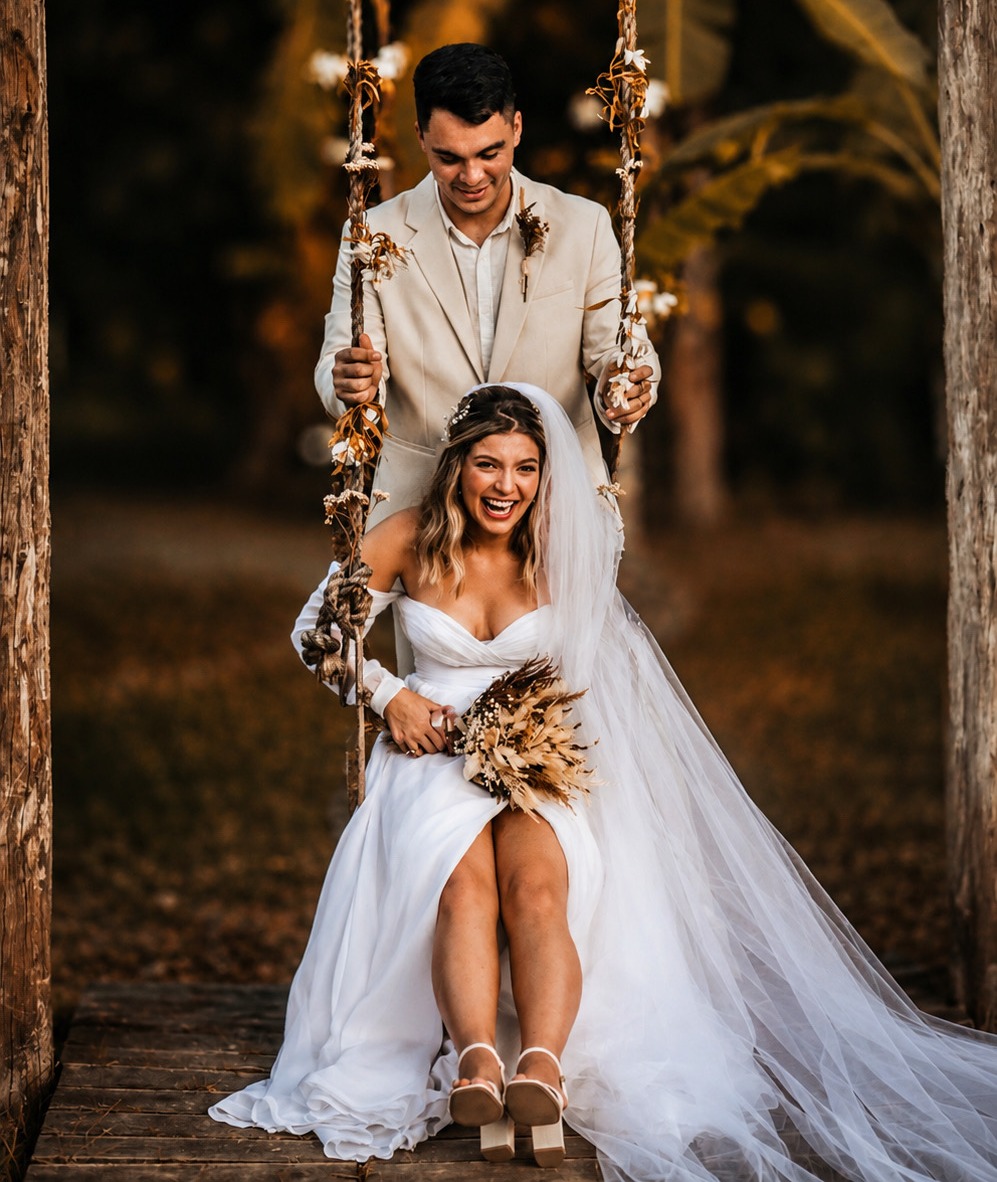 Couple de mariés sur une balançoire décorée de fleurs